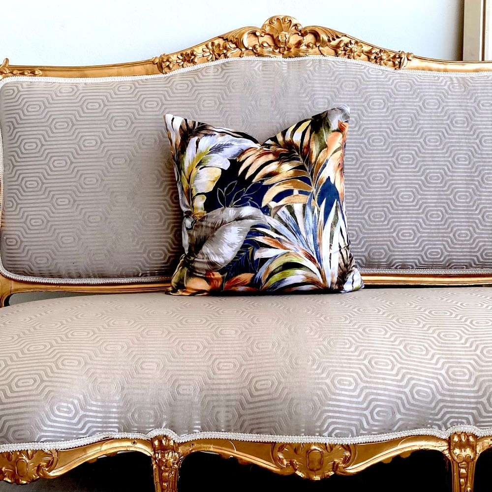 Decorative pillow on a ornate gold and gray sofa