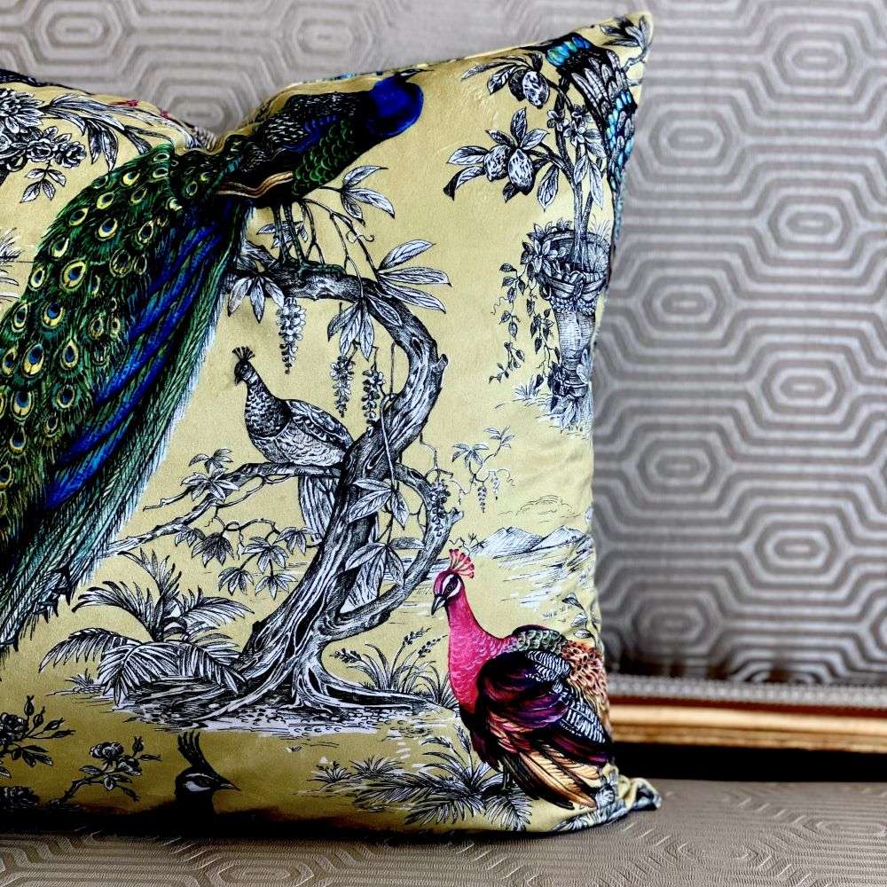 Decorative pillow with peacock and bird design on a textured surface