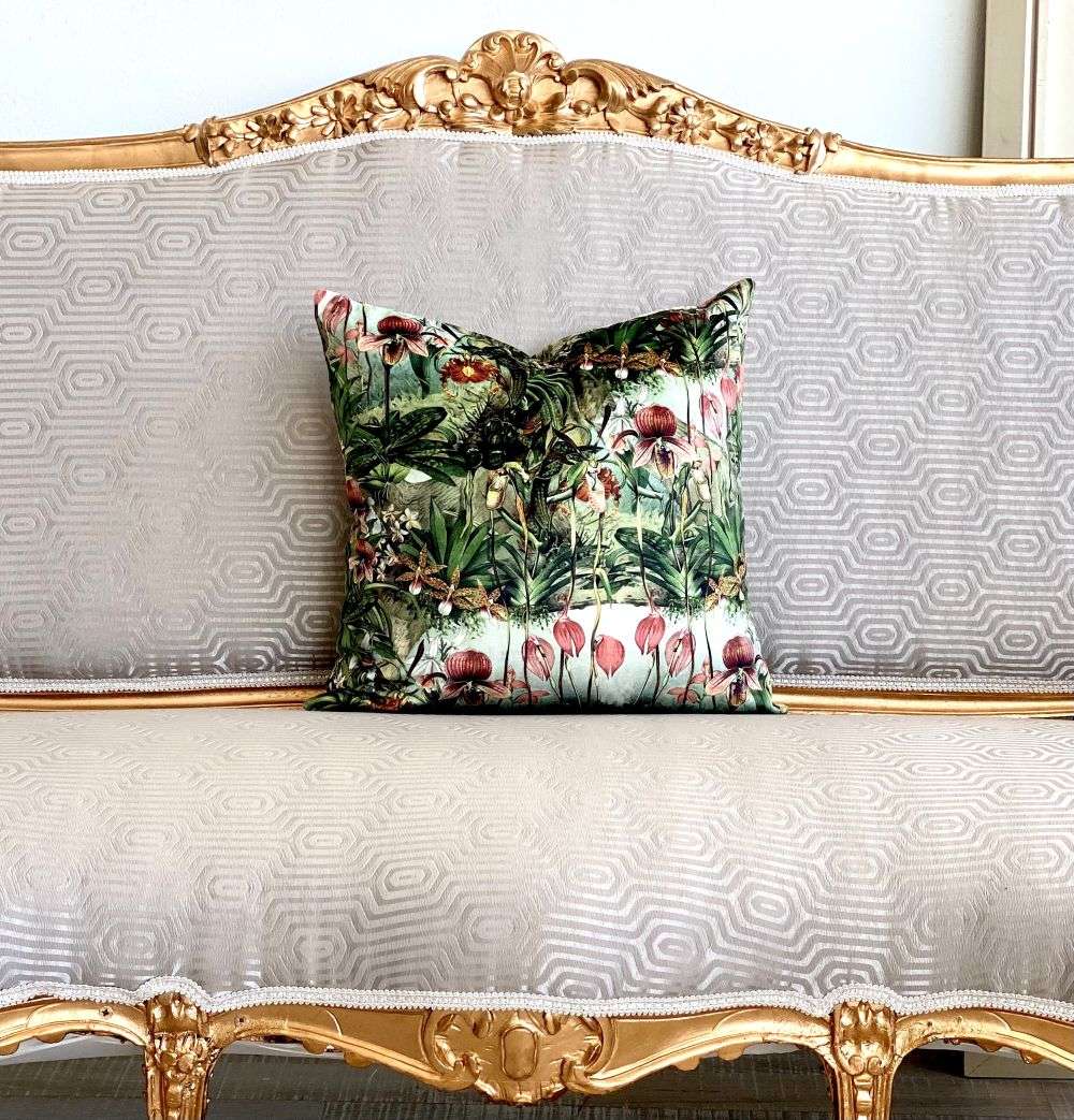 Decorative pillow with floral pattern on a ornate gold and white sofa