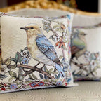Decorative pillows with bird designs on a textured surface