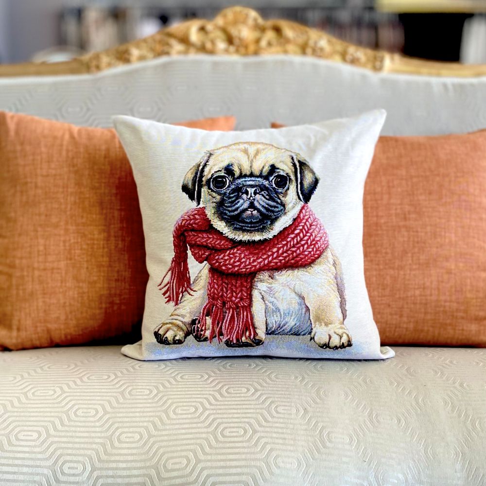 Decorative pillow with a pug wearing a red scarf on a couch.