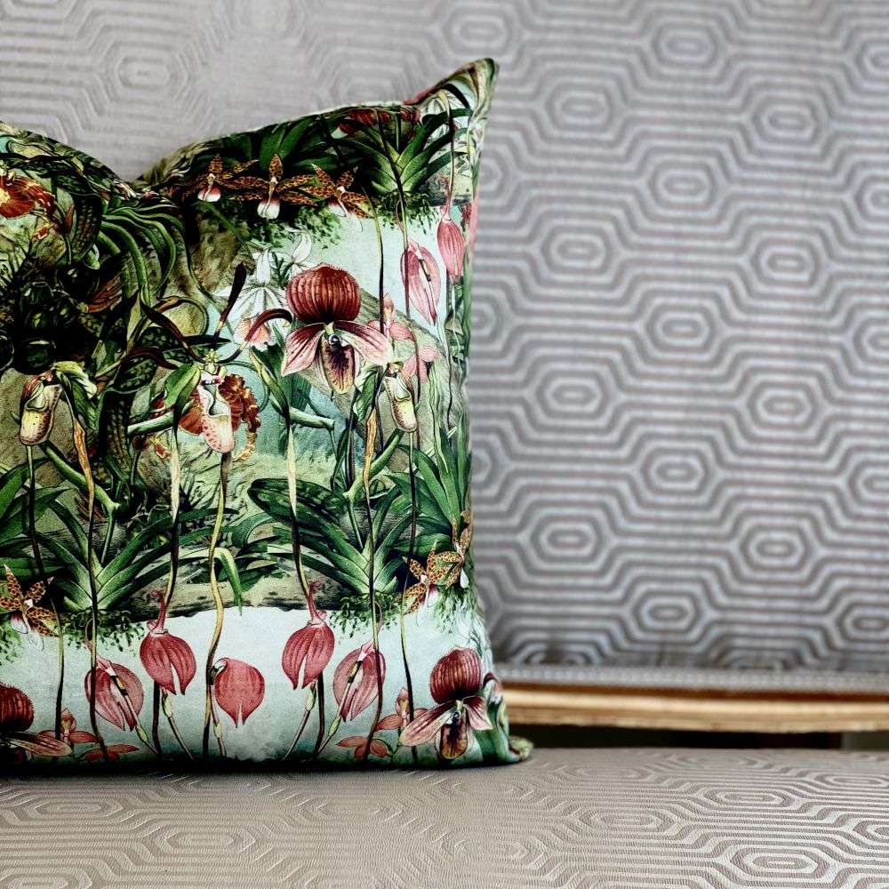 Decorative pillow with tropical floral pattern on a textured wall background