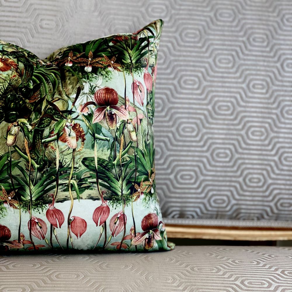 Decorative pillow with tropical floral pattern on a textured wall background