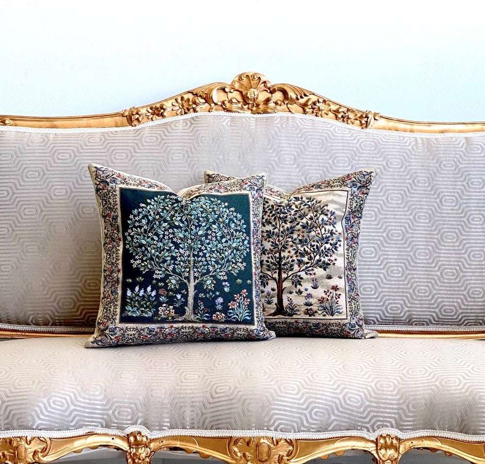 Decorative pillows with tree designs on a ornate sofa.