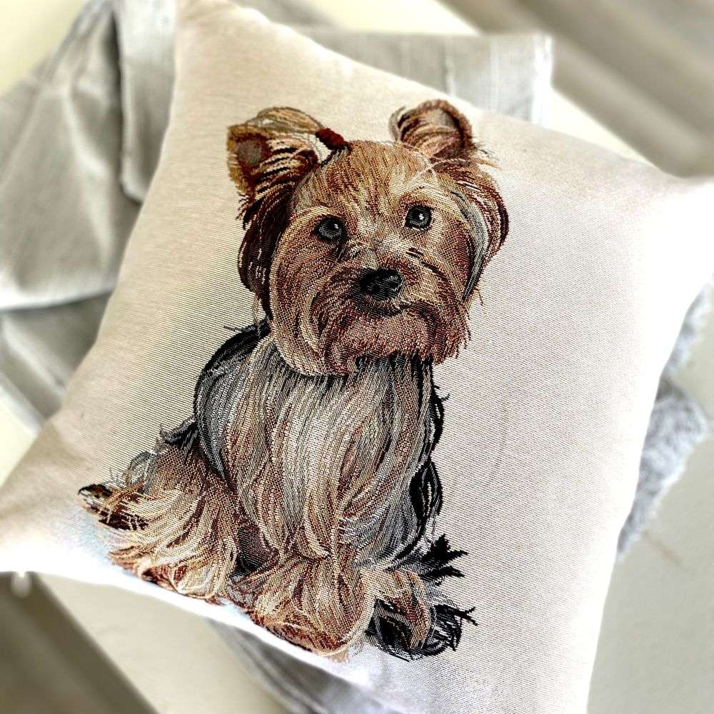 Embroidered pillow with a dog design on a neutral background