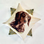 Decorative pillow with a dachshund design on a white background