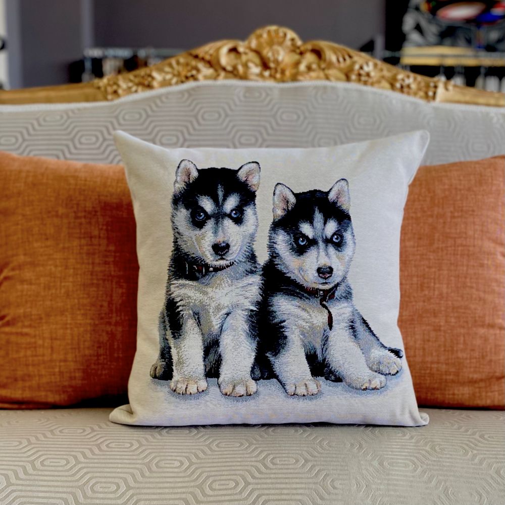 Decorative pillow with husky puppies on a couch