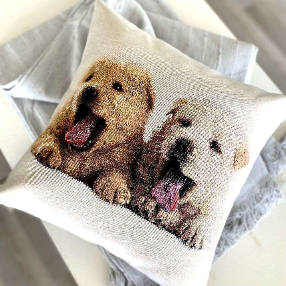 Decorative pillow with two dogs printed on it, placed on a soft surface.