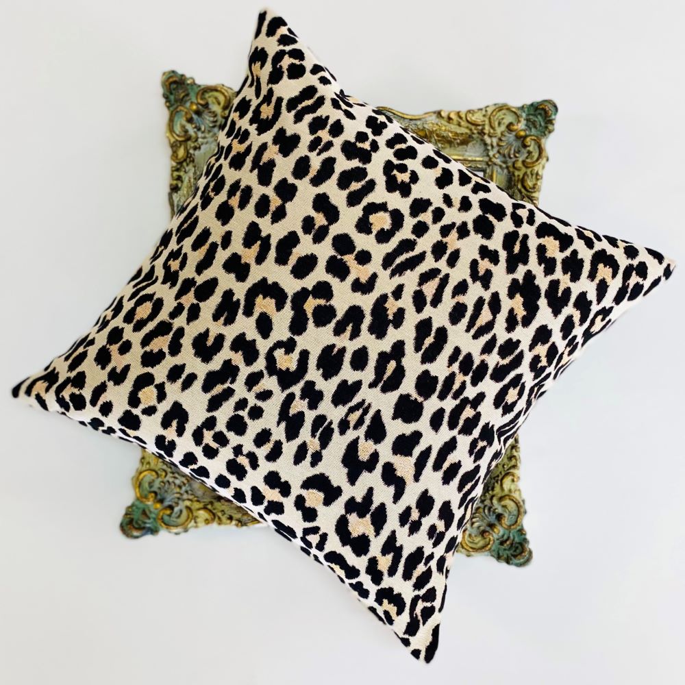 Leopard print pillow on a decorative pillow with a white background
