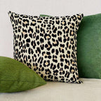 Leopard print pillow with green pillows on a neutral background