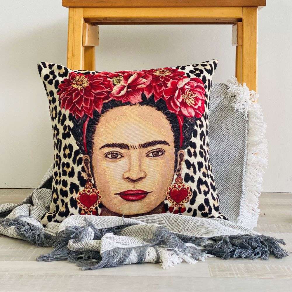 Decorative pillow with a portrait design featuring red flowers and leopard print on a wooden surface.