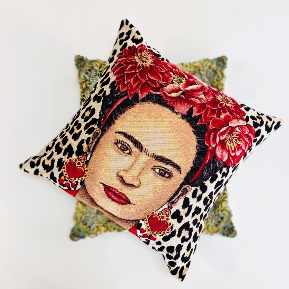 Decorative pillow with a face design, floral headband, and leopard print pattern on a white background.