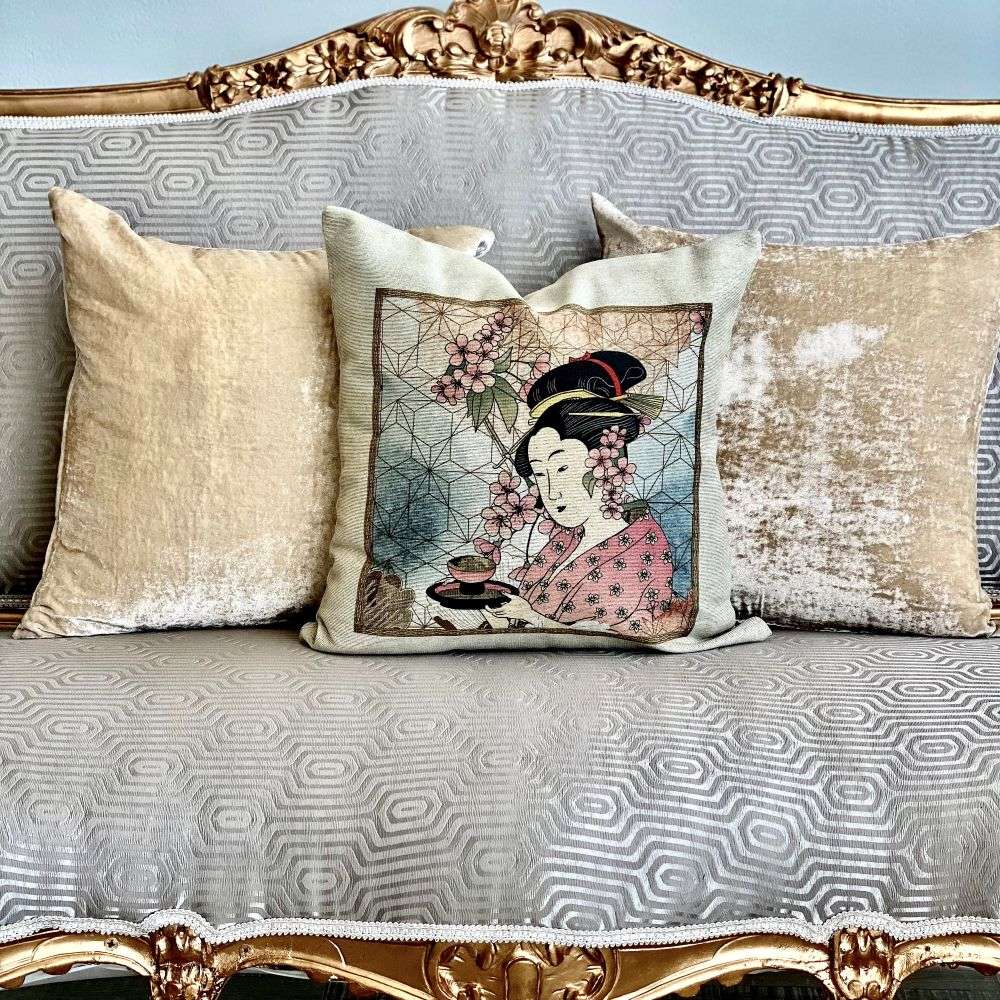 Decorative pillow with a floral design and figure on a patterned sofa.