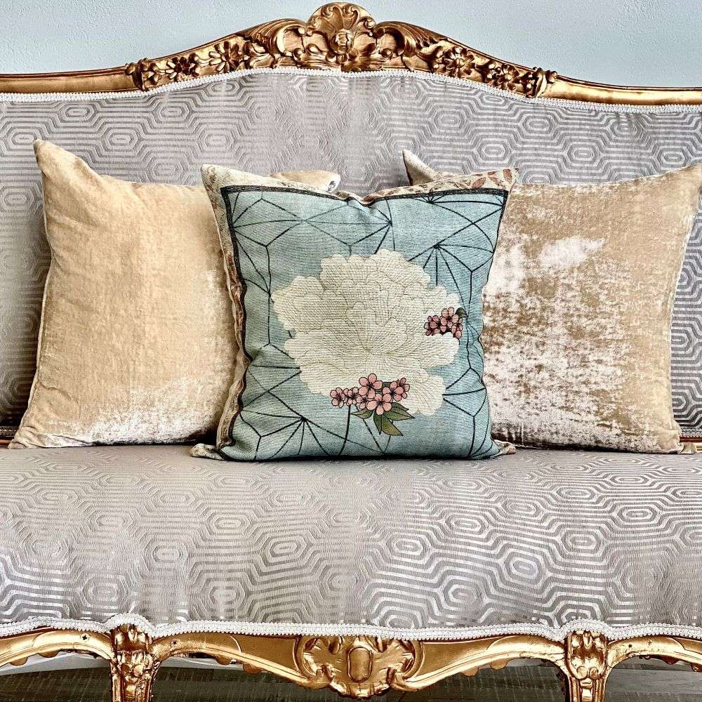 Decorative pillows on a patterned sofa with gold accents