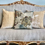 Decorative pillows on a patterned sofa with gold accents