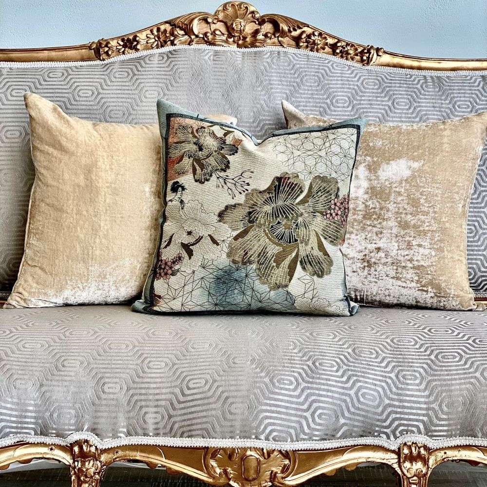 Decorative pillows on a patterned sofa with gold accents