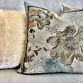 Decorative pillow with floral and geometric patterns on a couch.