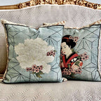 Two decorative pillows with floral and geisha designs on a patterned sofa.