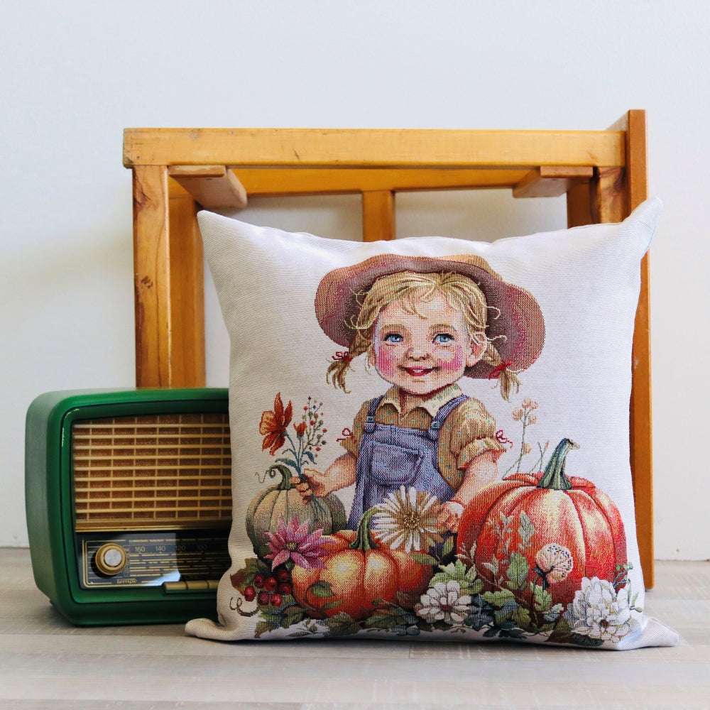 Decorative pillow with a child and pumpkins design next to a vintage radio on a wooden surface.